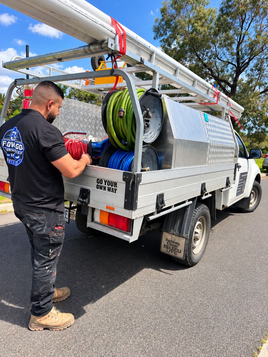 Flow and Go plumber loading hose reels onto the work ute